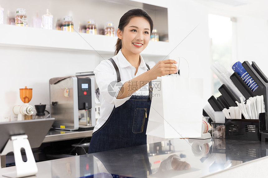 饮品店女性服务员递交外卖袋图片