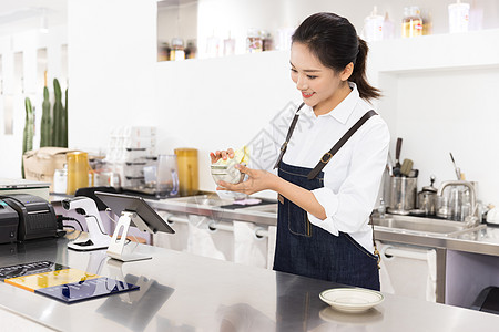 饮品店前台女性服务员擦杯子图片