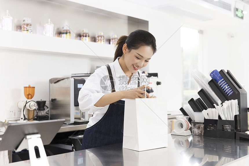 饮品店女性服务员递出外卖奶茶
