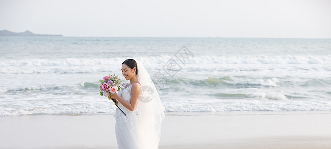 海边婚纱美女拿手捧花背景