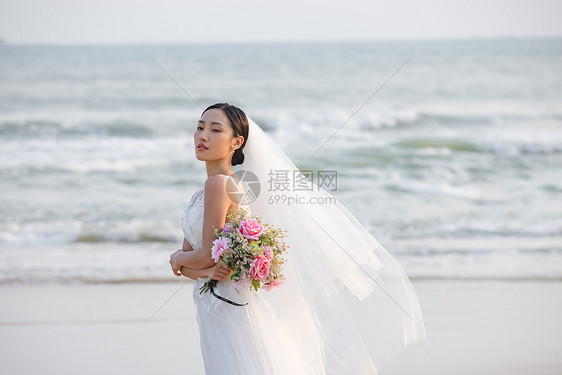 海边婚纱美女拿手捧花图片