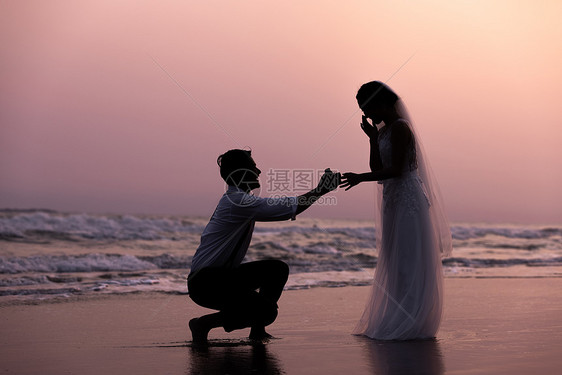 海边沙滩日落情侣求婚剪影图片