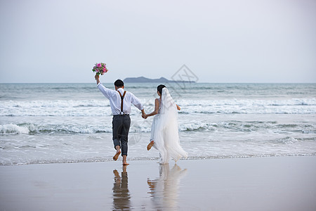 唯美婚纱照海边沙滩情侣夫妻奔向大海背景