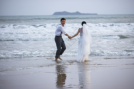 海边沙滩情侣夫妻奔向大海高清图片