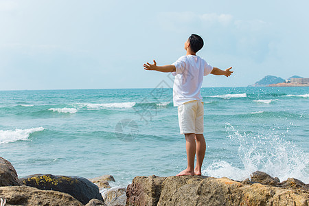 青年男性张开手臂拥抱大海背影图片