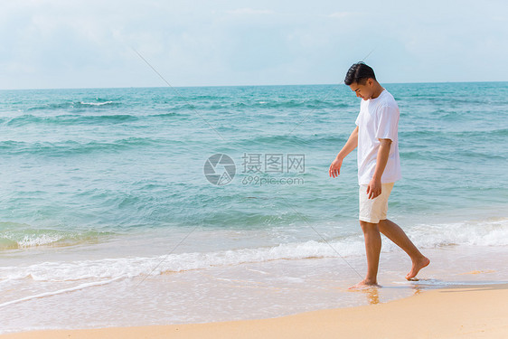 海边沙滩青年男性旅行散步图片