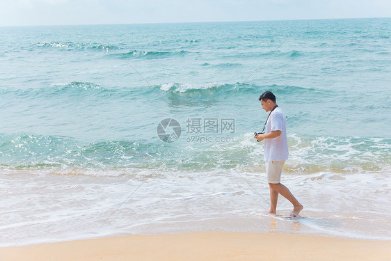 海边沙滩青年男性旅行散步图片