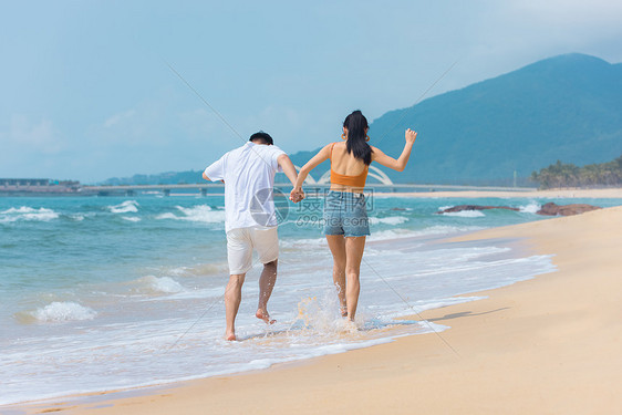 夏日情侣海边沙滩玩水图片