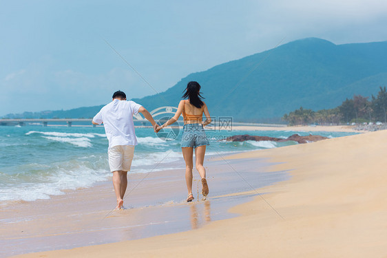 夏日情侣海边沙滩上奔跑戏水图片