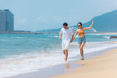 沙滩戏水夏日情侣海边沙滩上嬉戏戏水背景