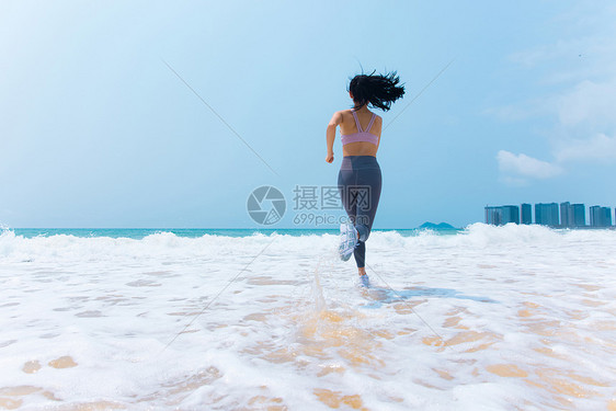 夏日海边沙滩女性运动奔向大海跑步背影图片