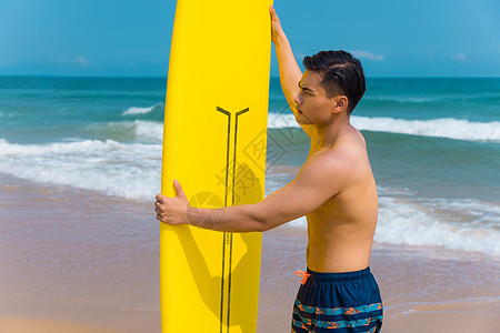 海边沙滩裤青年男性拿冲浪板图片