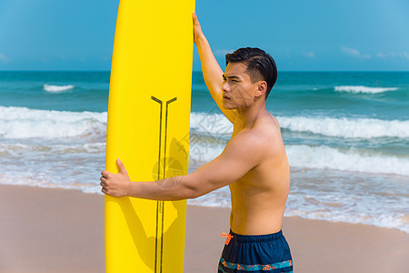 海边沙滩裤青年男性拿冲浪板图片