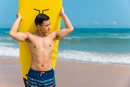 海边沙滩裤青年男性背冲浪板图片