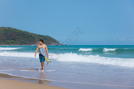 海边沙滩裤青年男性拿冲浪板高清图片