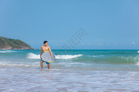 海边沙滩裤青年男性拿冲浪板图片