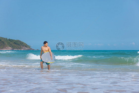 海边沙滩裤青年男性拿冲浪板图片