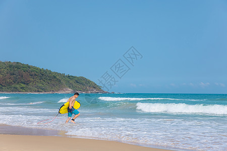 海边沙滩裤青年男性拿冲浪板走向大海图片