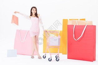 女性推着购物车举着购物袋图片