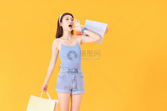 拿着购物的女性形象袋的年轻女性图片