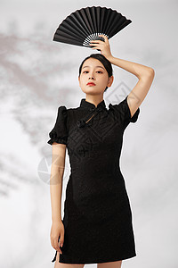 国潮旗袍美女举着黑色折扇图片