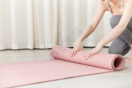 女性瑜伽锻炼整理瑜伽垫图片