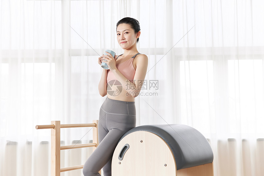 女性瑜伽健身手捧水杯休息图片