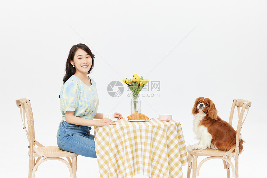 美女和宠物狗一起喝下午茶图片
