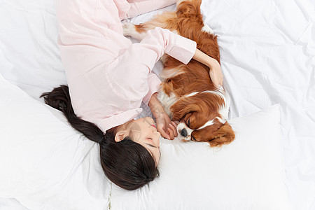 爱宠美女与宠物狗躺在床上图片