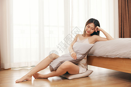 睡衣美女居家坐在床边休息图片