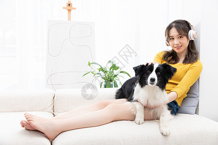 听音乐的美女主人抱着宠物牧羊犬图片