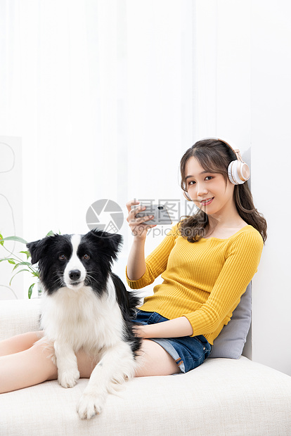 美女主人给宠物牧羊犬拍照图片