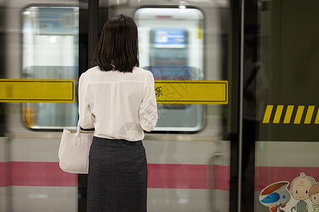 乘坐地铁下班的女性背影图片素材