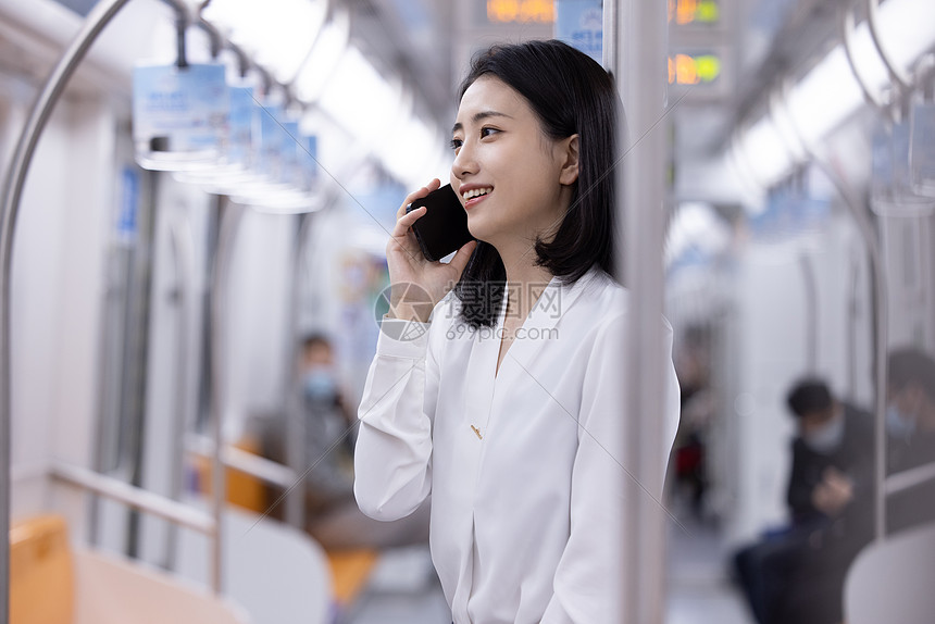 地铁上打电话的女性图片