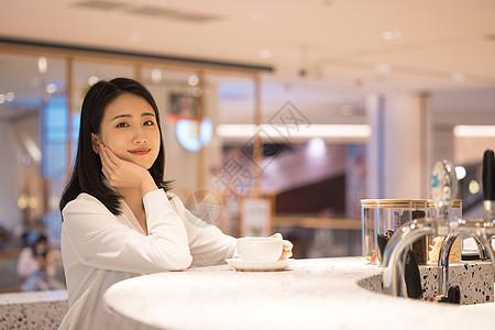 坐在咖啡厅休息的年轻女性图片