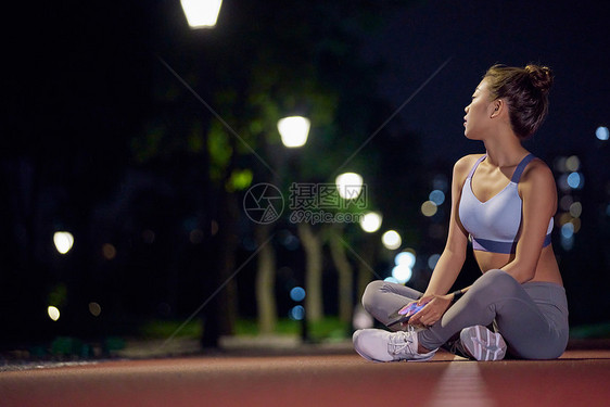 城市户外夜景健身美女休息图片