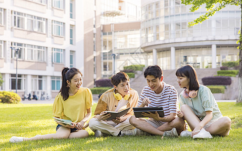 年轻大学生在草坪上讨论问题图片