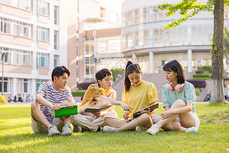 年轻大学生在草坪上讨论问题图片