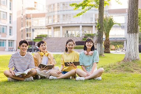 年轻大学生坐在草坪上形象图片