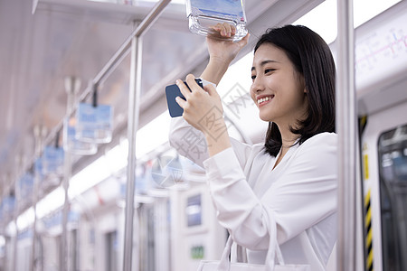 运行的地铁乘坐地铁下班的职场女性使用手机背景