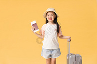 手拿机票和护照拉着行旅箱的小女孩图片
