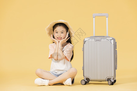 坐在行李箱边的小女孩背景图片
