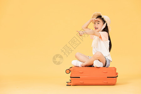 坐在行李箱上眺望远方的小女孩图片