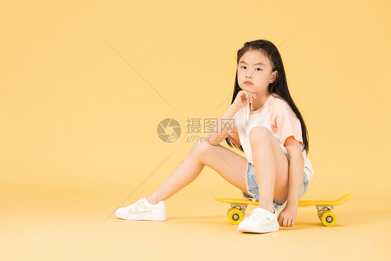 坐在滑板上的小女孩图片