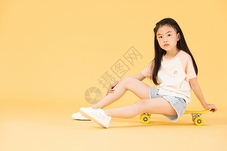 坐在滑板上的小女孩图片