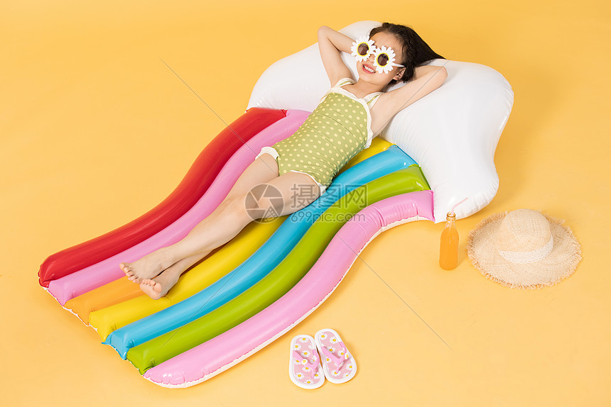 夏日泳装清凉儿童躺在充气床上图片