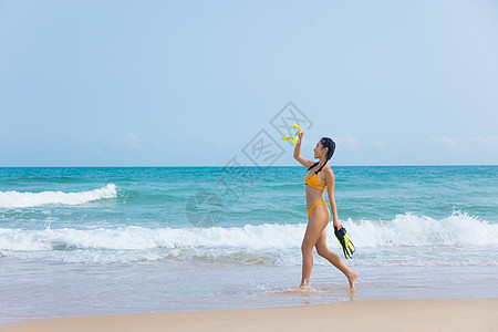 夏日比基尼美女拿着浮潜装备走向大海图片