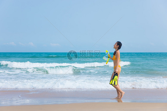 夏日比基尼美女拿着浮潜装备走向大海图片