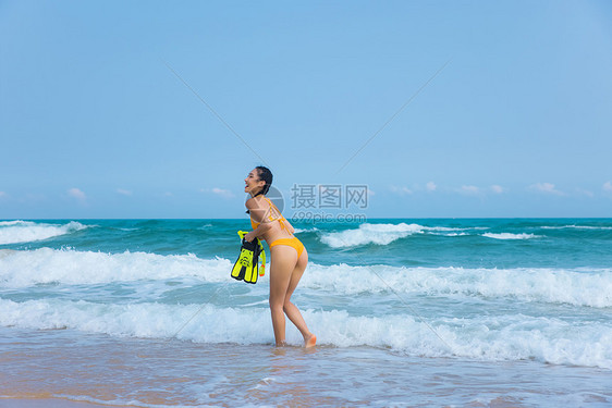 夏日比基尼美女拿着浮潜装备走向大海图片