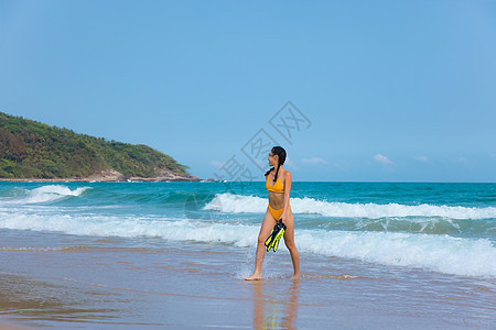 夏日比基尼美女拿着浮潜装备走向大海图片